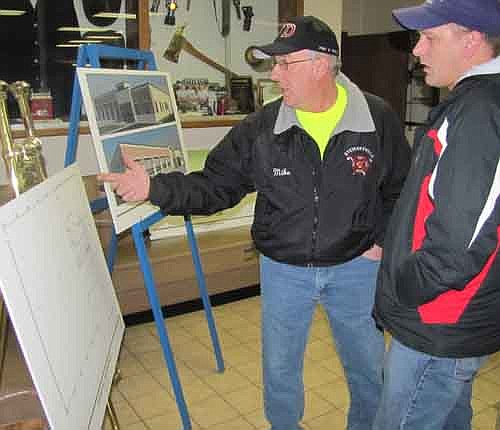 Mike Podein, a Stewartville firefighter, points to plans for Stewartville's new Fire Hall (drawings of which appear below), as Mike Thompson of Stewartville looks on at a Fire Department open house on Tuesday evening, Feb. 26.