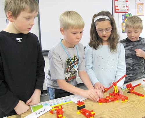 Bonner Elementary School students are using LEGOS to make levers in special classes after school on Thursdays. Here, Conner Lohmann, second from left, and Emma Rowen, second from right, work a LEGO&#8200;catapult while Tyler Giordano, far left, and Riley Schild, far right, look on.