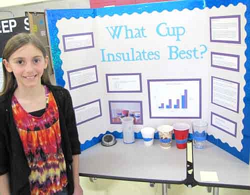 Alyssa Jones, a fourth grader at Central Intermediate School, displays her project at the school's annual Science Fair last week. Alyssa conducted an experiment to determine the best insulator among Styrofoam, paper, plastic and glass. She discovered that Styrofoam was best and glass was worst.