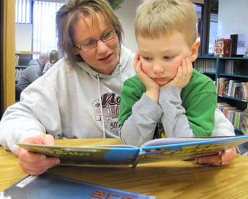 Mary Nagel of Stewartville reads the book "Sea Turtles" to her son Ethan, 4, during Wee Care Bedtime Stories at the Stewartville Public Library on Tuesday evening, March 12.  Barb Howes, director of Wee Care, said that the event, held in conjunction with "Read to Your Child Month" in March,  is designed to introduce families to the Stewartville Public Library.