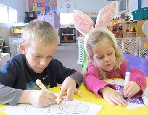 Brecken Rester, 5, left, and his sister Elise, 2, of Stewartville, work on an Easter coloring project at the Stewartville Child Care Center last Thursday, March 28. The Child Care Center is affiliated with Stewartville Christian Church.