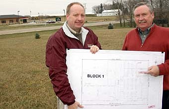 Bill Schimmel Jr., city administrator, left, and Mayor Chuck Murphy hold plans for Stewartville's new grocery store, which will be built on land to the right of First Farmers&Merchants Bank, the building at far left in the background.  