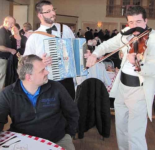 Neal Abbott, standing at center left, and Alex Weston, right, provided music from table to table at the Mama Tranchita Spaghetti Dinner at Riverview Greens on Tuesday, April 2.