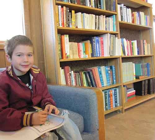 Allen Bredesen, 8, of Racine, visited the new community library at Racine United Methodist Church on Saturday, March 30. The small library has books available for children, teen-agers and adults.