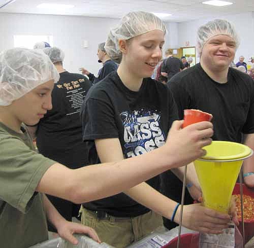 FOOD FOR THE HUNGRY -- From left, Lucas Uhlir, Kristen Conley and Shaun Uhlir, all students in Stewartville schools, work as a team to assemble meals for the poor at the 10th annual Food for Kidz event at the Stewartville Civic Center on Saturday, April 6. More than 300 volunteer workers assembled about 178,000 meals at this year's event, raising the local 10-year total to about 1,020,000 meals.