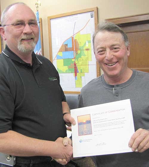 Mayor Jimmie-John King, right, accepts a certificate of commendation from Jeff Harrison, plant operator of Stewartville's wastewater treatment plant, at last week's City Council meeting. The certificate recognizes the city of Stewartville and its wastewater treatment facility staff for the city's "exemplary effort to comply with the Minnesota Pollution Control Agency's permit program." The commendation also states that the city's efforts "help protect and preserve the waters of Minnesota." The city of Stewartville has earned nine such certificates of commendation since 1992.