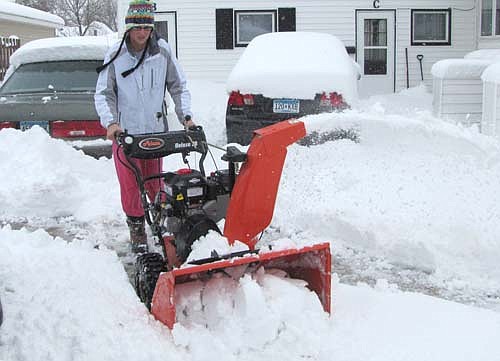 Katie Tweite uses a snowblower at the apartment complex at 204 Second Street Southwest to clear some of the 14 inches of snow that fell on Stewartville and the area on Thursday, May 2.  The record snowfall for that date forced local schools to close all day last Thursday and part of the day on Friday, May 3.