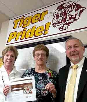 Evie Hintz, center, displays the Tiger Token she earned for volunteering at Bonner Elementary School for 22 years. Hintz, a Sears retiree, began volun<!--1up-20-->teering for teacher Louise Sorenson, left, in 1991. Dave Nystuen, principal at Bonner, right, presented the Tiger Token to Hin<!--1up-20-->tz at last week's School Board meeting.