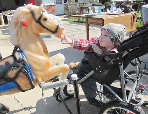 Wesley Neuvirth, 16 months, of Dexter, meets a rocking horse at Chris and Julie Gawarecki's garage sale that was held as part of Stewartville's citywide sale last Friday morning, May 10. Michelle Neuvirth, Wesley's mother, bought the rocking horse a few minutes after the photo was taken.