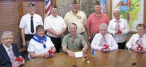 Mayor Jimmie-John King, seated in center, signed a proclamation last week declaring May as Poppy Month in the city of Stewartville. This month, the Stewartville American Legion Post 164, American Legion Auxiliary Unit 164, the Veterans of Foreign Wars (VFW) and the Veterans of Foreign Wars Auxiliary will distribute poppies to residents in exchange for a donation to help veterans and their families. "The memorial poppy, assembled by disabled veterans, pays respectful tribute to those killed in war, and also benefits living veterans and their families," King's proclamation declares. VFW members will distribute the poppies at local stores this Wednesday, Thursday and Friday. Those from local veterans organizations involved in the distribution include, front row, from left, Charlotte Kath, Peggy Paulson, (Mayor King), Viny Byrne and Marilyn Howard. Back row, from left, Tom Wacholtz, Roger Peterson, Richard Paulson, Wes Alrick and Audrey Farnsworth.