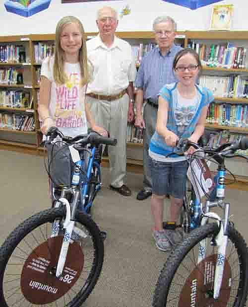 Erin Lamb, left, a Central fourth grader, and Kayla Meyer, a fifth grader, have won bicycles courtesy of the Stewartville Masonic Lodge. Students who read books earn tickets to for a drawing.  In back are Bob Lee, left, and Len Griffith of the Masonic Lodge.