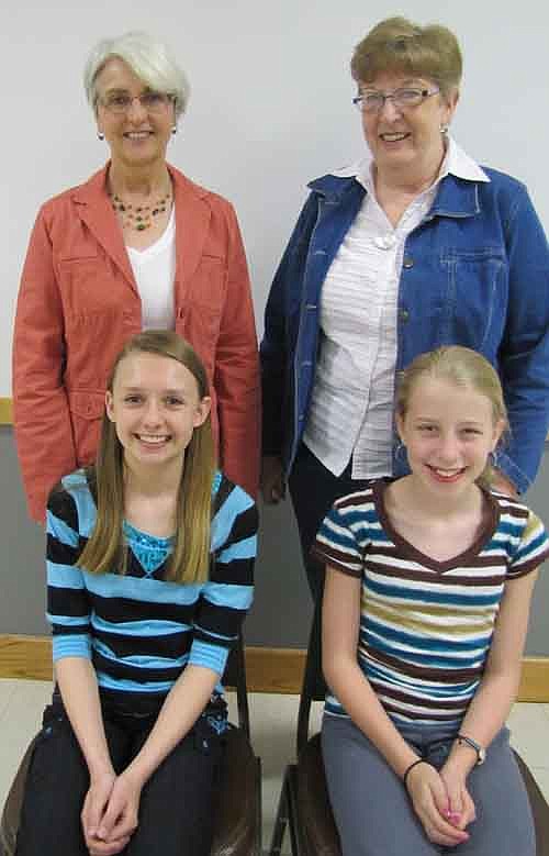 Three sixth graders at Stewartville Middle School have been chosen as the winners in a contest that challenged the students to write essays about their favorite older person. Winners include Autumn Feine, seated at left, who wrote about her grandmother, Beverly Feine, standing at left; and Ellie Fryer, seated at write, who wrote about Lois Anderson, a family friend, standing at right. Student Madalyn Ostby and her favorite older person, Harriette "Grandma Bud" Bud, are not pictured.