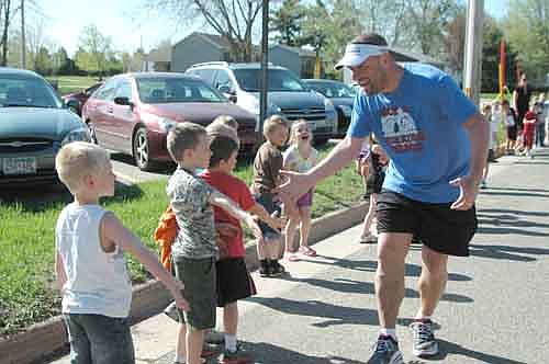  Jim Parry, a sixth-grade teacher at Stewartville Middle School, slaps hands with students from Bonner Elementary School during the early stages of Mr. Parry's Endurance Challenge on Thursday morning, May 16. Parry, who attempted to run and walk for 24 consecutive hours from Thursday morning to Friday morning, discontinued his effort after completing 47 miles in 17 hours. Last Thursday's hot and humid weather took its toll. "I was zapped by about noon or 1 p.m.," he said. For details, see the story in next week's STAR.
