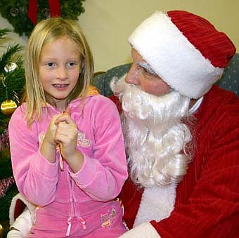 THINKING ABOUT CHRISTMAS -- Anna Oeltjenbruns, 7, a second-grader at Bonner Elementary School, ponders her Christmas wishes while meeting with Santa at the Stewartville Civic Center on Saturday, Dec. 1. 