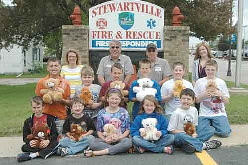 Deana Dontje's special education students at Central Intermediate School earned bears for their good behavior at school this year. Last week, the students donated the bears to the Stewartville Fire Department, which will give them to children who have endured emergency situations. Students include, front row, from left, Tristan Sieler, Christian Knipe, Emma Thomason, Emma Dolton and Joshua Conn. Second row, from left, Gideon Russel, Burkely Ravenhorst, David Black, Isaac Price, Michael Westfall and Dale Hulbert. Back row, from left, Jenny McHenry, special education paraprofessional, Mark Podein and Mike Podein of the Stewartville Fire Department, and Deana Dontje, special education teacher.