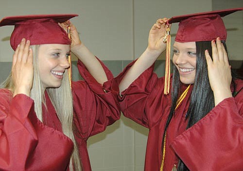 Paige Tapp, left, and her twin sister Hannah are almost mirror images of each other as they adjust their mortarboards before the members of the Stewartville High School class of 2013 marched into the SHS gym to the tune of Pomp and Circumstance last Friday evening, May 31. In all, 128 graduates received diplomas that evening.