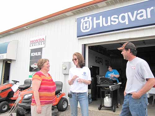 Kari York, vice president of First Farmers & Merchants Bank of Stewartville, left, talks with Bill and Angela Carr at the open house for Carr's Hilltop Repair & Services on Friday, June 14. 