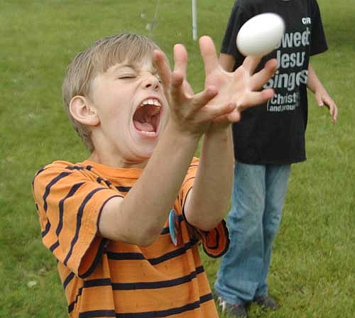 Nathanael Biffert, 9, of Stewartville, who will be a fourth grader at Central Intermediate School, catches an egg, left, during the egg toss at the High Forest Old Settlers Day on Saturday, June 15.
