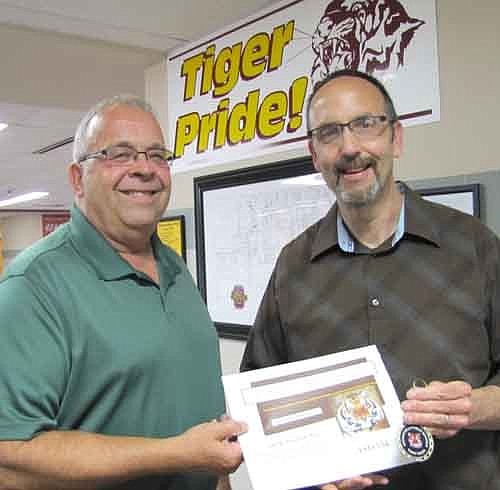 Gary Kadansky, right, accepts a Tiger Token from Bruce Hoff, principal of Stewartville High School.