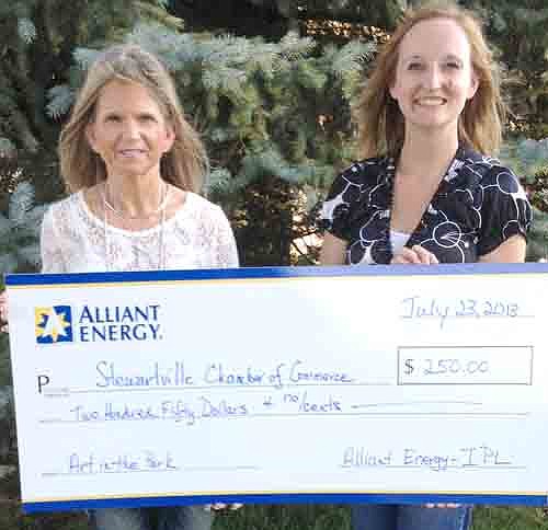 Alliant Energy was a Stewartville Summerfest sponsor and its donation to the Stewartville Chamber of Commerce provided a free craft station at the July 4 Arts in the Park at Florence Park called "ArtOrg." Here, Rebbecca Gisel presents a check from Alliant Energy to Chamber Administrator Melissa sue Leuning.