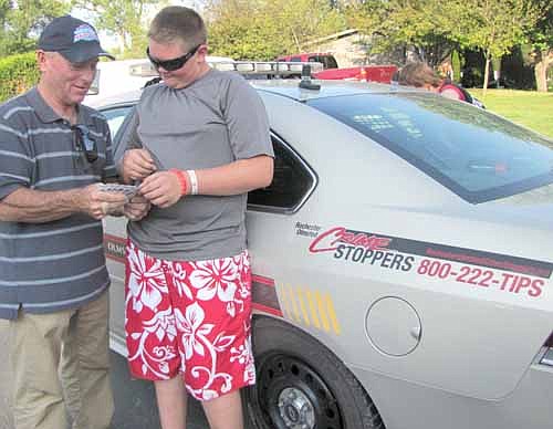 Mayor Jimmie-John King, left, hands out baseball cards to Tyler Schandorff, 13, of Stewartville, at the annual National Night Out event at Stewartville's Southern Hills last Tuesday evening, Aug. 6.