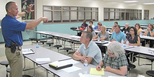 Capt. Kevin Torgerson of the Olmsted County Sheriff's Office, left, speaks to school, community and fire officials about emergency preparedness at Stewartville High School last Tuesday, Aug. 20. The event was titled "Operation School Readiness II."