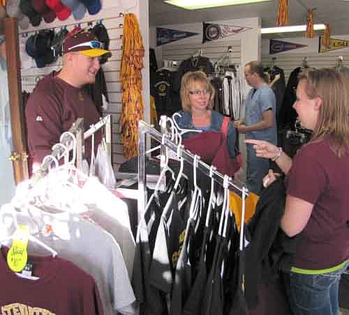 CASH MOB BROWSERS -- From left, Ryan Jacobson, Lori Homan and Brianna Homan look for items at C&M Screen Printing as part of the Stewartville Area Chamber of Commerce Cash Mob that visited the store last Thursday, Sept. 12. 