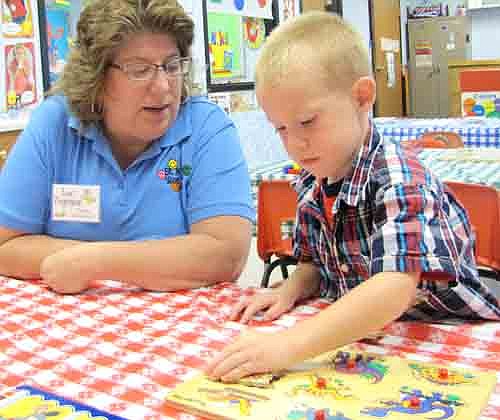 Ryan Cross, 3, works on a puzzle under the watchful eye of teacher Lori Torgerson at the annual Wee Care Open House on Sunday afternoon, Sept. 8. The event is held to give Wee Care teachers and students a chance to meet before the new school year begins.