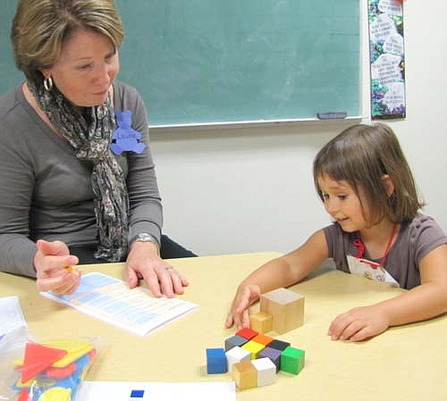 Volunteer Becky Case, left, works with Olivia Regal, 3, who arranges building blocks at the Early Childhood Screening at Grace Evangelical Free Church last week. More than 50 children attended the screening last Monday, Oct. 7 and Tuesday, Oct. 8.