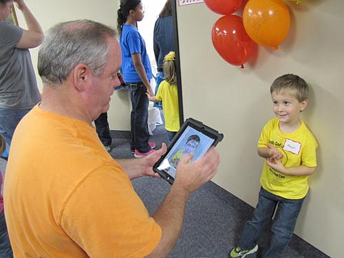 Wee Care celebrated its 30th anniversary with a festive carnival at St. John's Lutheran Church on Saturday, Oct. 5. Mason Pheifer, 4, of Racine, smiles for a photo as John Howes works the technology to add clown makeup to Mason's face.