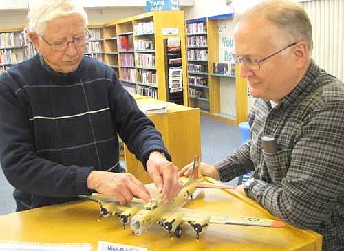 Richard King, a long-time Stewartville resident, left, shows a model of a B-29 Superfortress plane to Ron Johnson at the Stewartville Public Library, where King shared his World War II&#8200;training experiences with about 15 listeners on Thursday, Oct. 24.