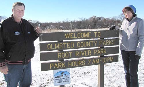 Bob Horstmann, left, and Sandi Johnson stand near a sign that welcomes visitors to the Root River Regional Park and Recreation Area, a 90-acre site about 10 miles northeast of Stewartville. Horstmann, Johnson and other area residents oppose Olmsted County's plans to draw an Official Map indicating that their properties could one day become part of the park.