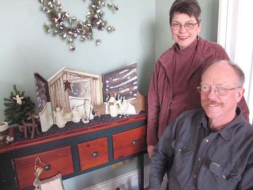 Ronn and Shirley Carlson, posing near a Nativity scene, live in the historic home built by the Wooldridges, a founding Stewartville family.