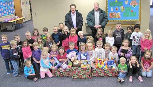 Gene Gustason, left, and Bill Schimmel Jr. of the Stewartville Lions Club, standing in back, visited St. John's Wee Care on Thursday, Dec. 5 to collect gifts donated by Wee Care families to the annual Lions Club Christmas Anonymous gift and fund drive. Each year, the Lions deliver the gifts to the Rochester Area Distribution Center in Rochester. To take part in Christmas Anonymous, residents may bring unwrapped toys, games, clothes and other gifts to Central Intermediate School, First Farmers&Merchants Bank or Eastwood Bank by Thursday, Dec. 12.  New and gently used items and cash donations will be accepted. Schimmel has said that gifts collected in Stewartville will stay in Olmsted County. "They'll go back to the local residents," he said.