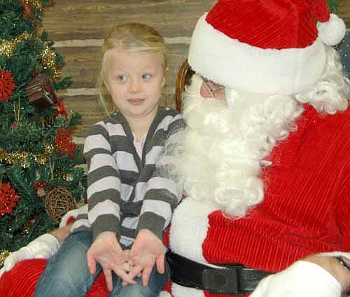 Amelia Petersen, 4, thinks hard before she talks with Santa Claus at the Stewartville Civic Center on Saturday morning, Dec. 7. Amelia is one of hundreds of children who visited with the Jolly Old Elf during the Stewartville Kiwanis Club's annual Pictures with Santa event.