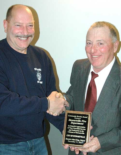Steve Wolf, Stewartville fire chief, left, accepts the Mayor's Award for Community Service from Mayor Jimmie-John King at the city's awards and recognition event last week.
