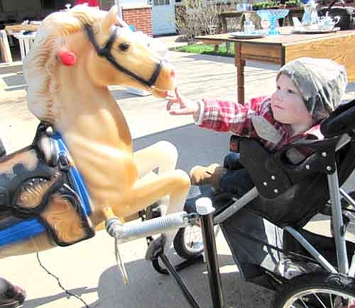 Wesley Neuvirth, 16 months, of Dexter, meets a rocking horse at Chris and Julie Gawarecki's garage sale in Stewartville last May 19.