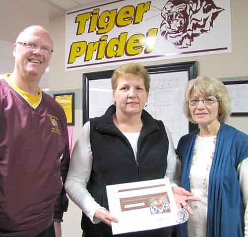 Chris Floyd, center, accepted a Tiger Token from Eldon Anderson, principal of Central Intermediate School, left, last week. Floyd volunteers to help Ginny Hanson, a teacher at Central, right.
