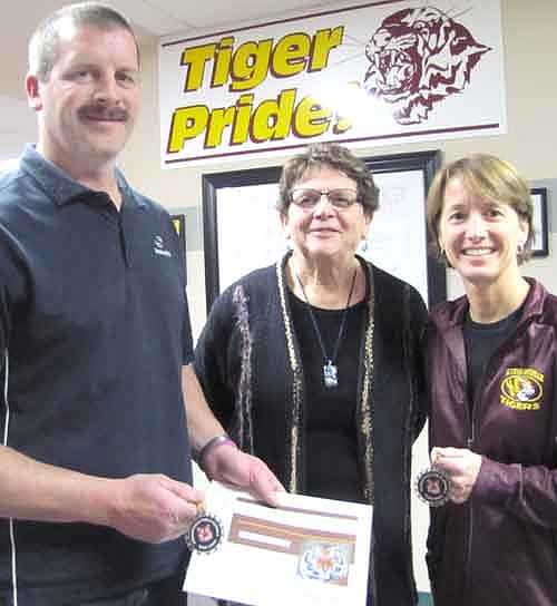 David and Cheryl Terhaar, at left and right, accepted Tiger Tokens from Sharon Morlock, athletic director for Stewartville schools, last week. The Terhaars volunteer to help with many athletic events.