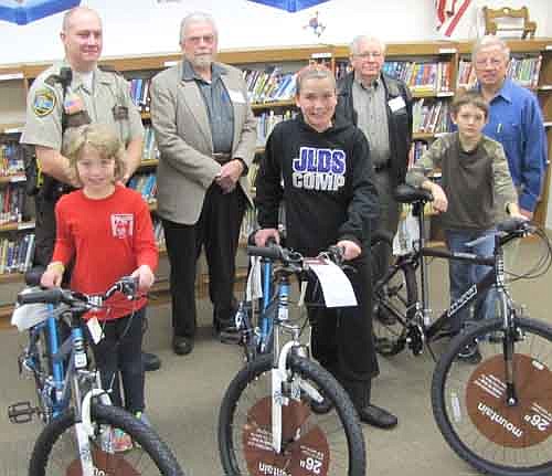 Three students at Central Intermediate School have won bicycles courtesy of the Stewartville Masonic Lodge and the Olmsted County Deputy Sheriffs Association. Students include, front row, from left, Kadrian Scheevel, a third grader; Khloee Zelinske, a fifth grader; and Damon Rubin, a fourth grader. To be eligible to win a bicycle, a student must read a book, then enter  his or her name for each book read in a drawing held each December and May. In back, from left, are Zak Breitenbach, Stewartville's community oriented policing (COPS) deputy; and George Menshik, George Thompson and Len Griffith of the Stewartville Masonic Lodge. Menshik spoke briefly to Central's students at an all-school assembly on Friday, Dec. 13, saying, "Reading is probably one of the most important things you'll learn at school. There's nothing that beats reading books. That's why the Masonic organization here in town is behind this program...We hope you'll read as many books as possible."