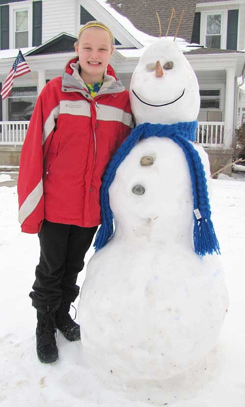 Bella Kruger, 12, a sixth grader at Stewartville Middle School, above, and her sister Ava, 9, have built a replica of Olaf the Snowman from the movie Frozen in front of their Lakeshore Drive home. It took the girls about 90 minutes to build the snowman, which has a carrot for a nose and stones for eyes and buttons.