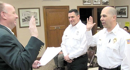 Vance Swisher, in the foreground at right, takes the oath of office to become Stewartville's new fire chief for 2014. Larry Mueller, in the background at right, was sworn in as assistant fire chief. Bill Schimmel Jr., city administrator, administered the oath of office at last week's City Council meeting. Lisa Jelinek, director of Stewartville First Responders, did not attend last week's meeting. She will be sworn in at a later date.