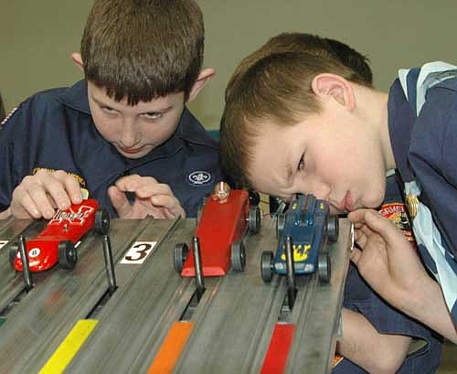 Jake Halferty, left, and an unindentified Scout focus all their attention on lining up their cars to race at the annual Pinewood Derby at Grace Evangelical Free Church on Saturday, Jan. 25.