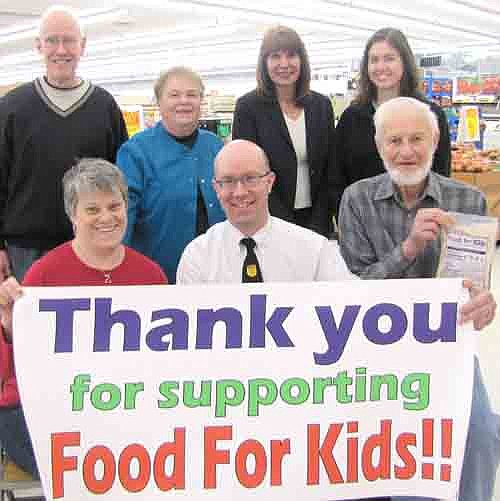 Robert Hruska, grocery manager at Fareway of Stewartville, seated in center, welcomes residents to donate to Food for Kidz at Fareway's checkout counters through February. A few of the Kiwanis Club members working on the project include, front row, from left, Mary Brouillard and Roy Gisler.  Back row, from left, Lincoln Harker, Iz Wilken, Kim Brown and Laura Wiles.