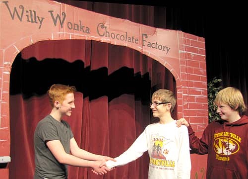 Willy Wonka (Jack Wood), left, welcomes Charlie (Shawn Husgen) to Willy Wonka's Chocolate Factory with a cordial handshake as Grandpa Joe (George Gray) looks on during a rehearsal for the Stewartville Middle School performance of "Charlie and the Chocolate Factory" to be presented at the Performing Arts Center this Friday, Feb. 14 and Saturday, Feb. 15 at 7 p.m. each evening, and this Sunday, Feb. 16 at 2 p.m. Gary Kadansky, director, said that the play is set to go just in time for Valentine's Day. "It's an honor to work with these kids and to see the joy in their hard work,"&#8200;he said.