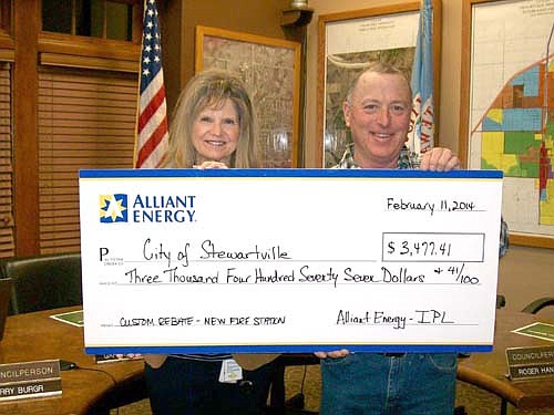 Rebecca Gisel, key accounts manager for Alliant Energy, presents a rebate check for $3,477.41 to Mayor Jimmie-John King at last week's City Council meeting.  Alliant presented the check to recognize the city for emphasizing energy efficiency for the new Stewartville Fire Hall. Features at the new facility include energy-efficient lighting, fan controls for exhaust fans and energy-saving insulation. "Alliant Energy wants to commend the city for its continued focus on energy efficiency," Gisel said.