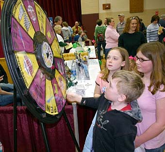 Joe Finley spins the wheel as Katie Finley and Marissa Koenigs look on at the annual Chamber of Commerce Home Show on March 13. 
