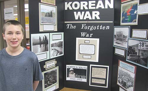 Derek Golliher, a sixth grader at Stewartville Middle School, displays his project "Korean War: The Forgotten War" at the school's History Day Fair last Thursday, Feb. 13. The war caused a lot of suffering, Derek said. "It was really bloody."