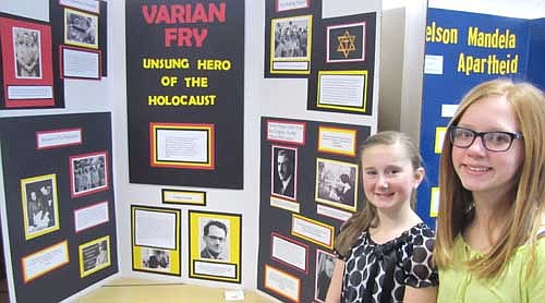 Alyssa Dwire, left, and Emily Sikkink display their group exhibit, "Varian Fry, Unsung Hero of the Holocaust" at the Stewartville Middle School History Day Fair last Thursday, Feb. 13. The girls were impressed with Fry, who saved about 2,000 Jews and others from the Holocaust. "It's amazing what you can do when you're brave," Alyssa said.