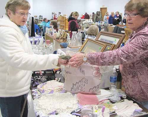 Irene Elton, right, who ran the "Used a Bit" shop in Stewartville for 15 to 20 years, makes a sale at the Cabin Fever Flea Market at the Stewartville Civic Center on Saturday, Feb. 15.